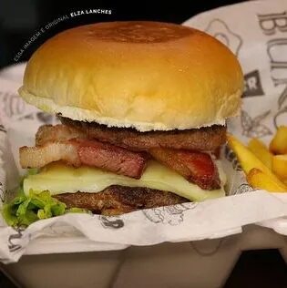 Hambúrguer com bacon crocante embrulhado no papel da casa, com fritas ao lado